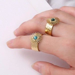 Detail of vintage gold sunburst rings with turquoise stone and hammered metal texture