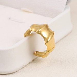 Détail d'une bague baroque dorée en acier inoxydable avec un design de liquide irrégulier