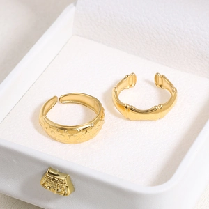Detail of gold geometric adjustable rings with star patterns in a jewelry box