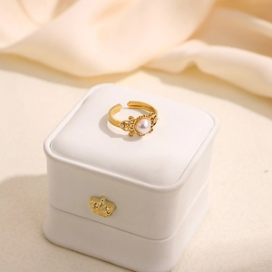 Détail macro d'une bague baroque dorée avec perles sur un écrin à bijoux royal