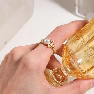 Bague vintage dorée avec gravures, perle centrale et détails filigranes élégants