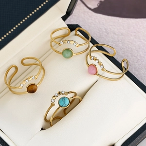 Detailed macro view of four adjustable layered rings with colorful stones and zircons