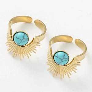 Close-up of bohemian sunburst rings featuring turquoise stone and gold sun ray details