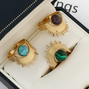 Adjustable sunburst gold rings with natural stone insets in a black jewelry box