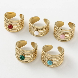 Detail of five bohemian style layered open rings with colorful natural stone inlays