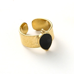 Detail of a wide gold-plated open ring with hammered texture and black waterdrop stone
