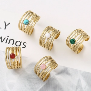Detail of five vintage gold open rings with various colorful gemstones and tiered textures