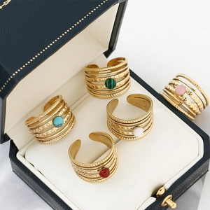 Detailed macro view of five-layered gold rings with assorted natural stone inlays