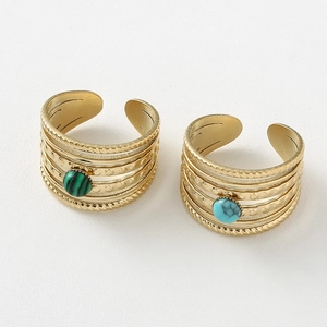Close-up of vintage multi-layer stainless steel open rings with malachite and turquoise