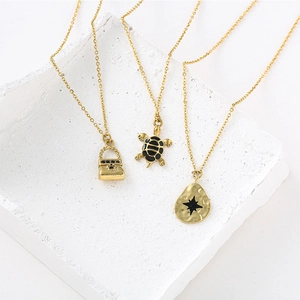 Colliers dorés avec pendentifs sac à main, tortue et étoile en émail noir sur pierre