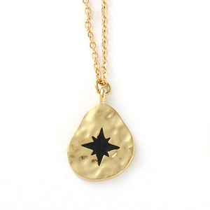 Détail du collier à pendentif martelé doré avec incrustation d'étoile noire élégante