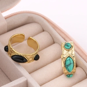 Bagues dorées vintage texturées avec pierres noires et turquoise dans un écrin