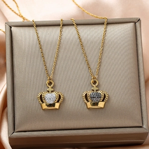 Close-up of gold crown necklaces with black and white zircon inlay in a jewelry gift box