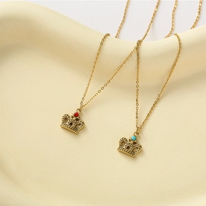 Elegant gold crown pendant necklaces with red and blue natural stones on white display