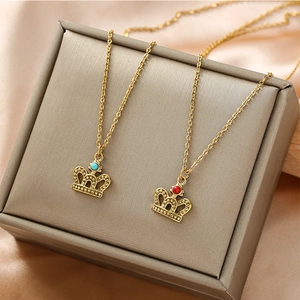 Golden crown necklaces with red and blue natural stones on champagne silk background