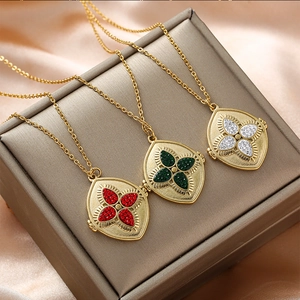 Vue détaillée de trois pendentifs trèfle dorés vintage avec cristaux multicolores