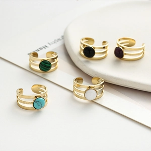 Detailed view of triple-layered gold rings with assorted colorful natural stone inlays