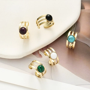 Detailed view of triple-layered gold rings with assorted colorful natural stone inlays