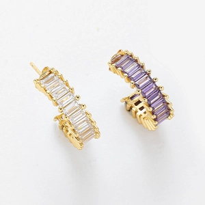 Détail de créoles en C avec des pierres de zircone cubique blanches et violettes baguette