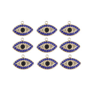 Detailed macro view of nine gold-plated evil eye charms with blue crystals on white background