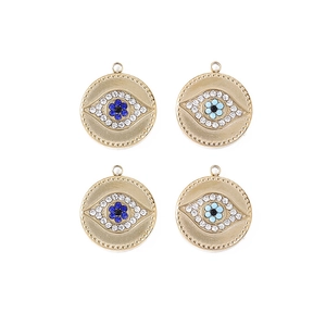Macro detail of four gold evil eye pendants with blue and white crystals for DIY jewelry