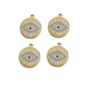 Detailed macro of gold evil eye charms with blue center and colorful crystals