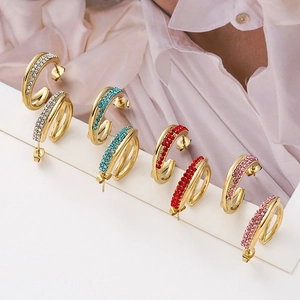 Detail of colorful cross-over C-shaped earrings with double-row crystal rhinestones