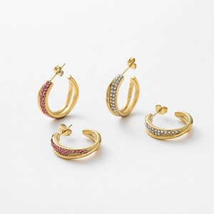 Detailed view of gold C-shaped earrings with crossed rows of pink and white rhinestones