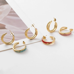 Detailed view of colorful C-shaped stainless steel earrings with sparkling zircon stones