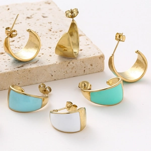 Detail of gold C-shaped earrings featuring colorful enamel inlay and butterfly backs