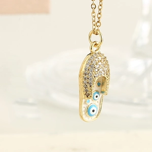 Collier avec pendentif chaussure mule dorée, pavé de zircons et œil maléfique
