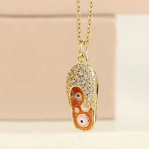 Collier doré avec pendentif pantoufle, design œil protecteur et cristaux sertis