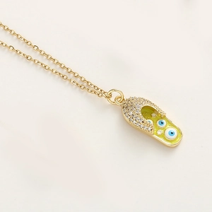 Détail d'un pendentif sabot plaqué or avec émail jaune et charmes d'oeil bleu