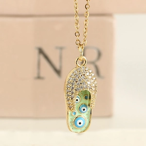 Gros plan du pendentif tong œil maléfique vert menthe avec oxydes de zirconium brillants