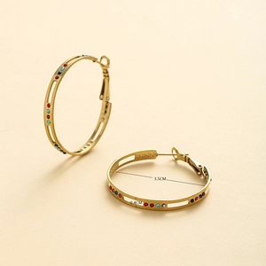Détail de créoles dorées de 3,5 cm avec strass multicolores et une largeur de 0,4 cm