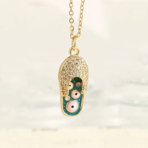 Vue macro détaillée du pendentif tong en or avec zircon et symboles du mauvais oeil