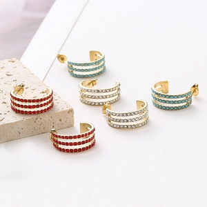 Three-row rhinestone C-shaped hoop earrings in gold with red, white, and blue crystals