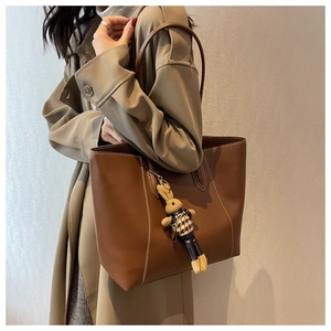 Détail du grand sac cabas marron foncé avec surpiqûres blanches et pendentif lapin