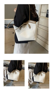 Detail of off-white lychee leather tote bag with brown contrast trim and slim straps