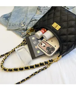 Detailed view of large capacity black quilted chain bag with various daily essentials inside