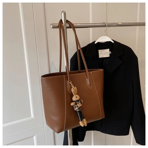 Vue détaillée du sac cabas en cuir marron avec surpiqûres blanches et charme de lapin