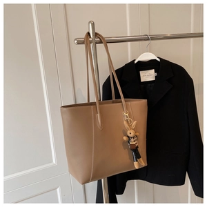 Détail du sac cabas marron clair avec surpiqûres blanches et pendentif lapin à carreaux