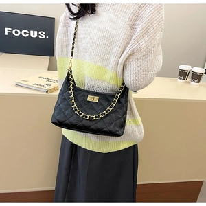 Close-up of black quilted hobo bag with gold chain and metal twist lock detail