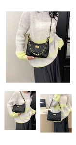 Detailed close-up of quilted chain bag with gold rotating lock and elegant strap