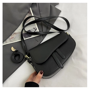 Close-up of black leather saddle bag with smooth matte finish and gold buckle