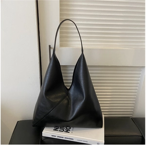 Detail view of a black vintage soft leather hobo bag placed on white decorative props