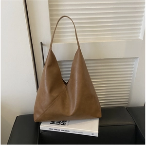Detail of soft brown leather tote bag with unique triangular shape and diagonal stitching