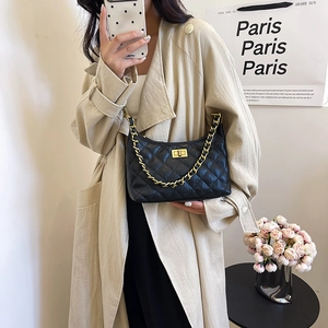 Chic black quilted leather hobo bag with gold chain strap worn with a stylish trench coat