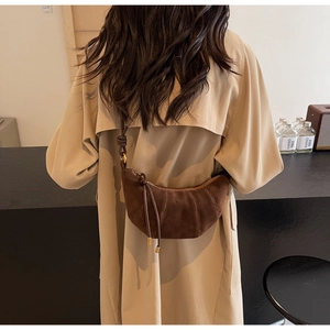 Brown frosted leather crescent croissant bag styled with a tan trench coat
