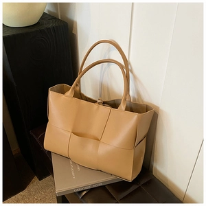 Detail shot of the khaki hand-woven tote bag showing the Intrecciato leather texture